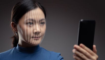 Asian woman having face scanned for authentication on her smartphone