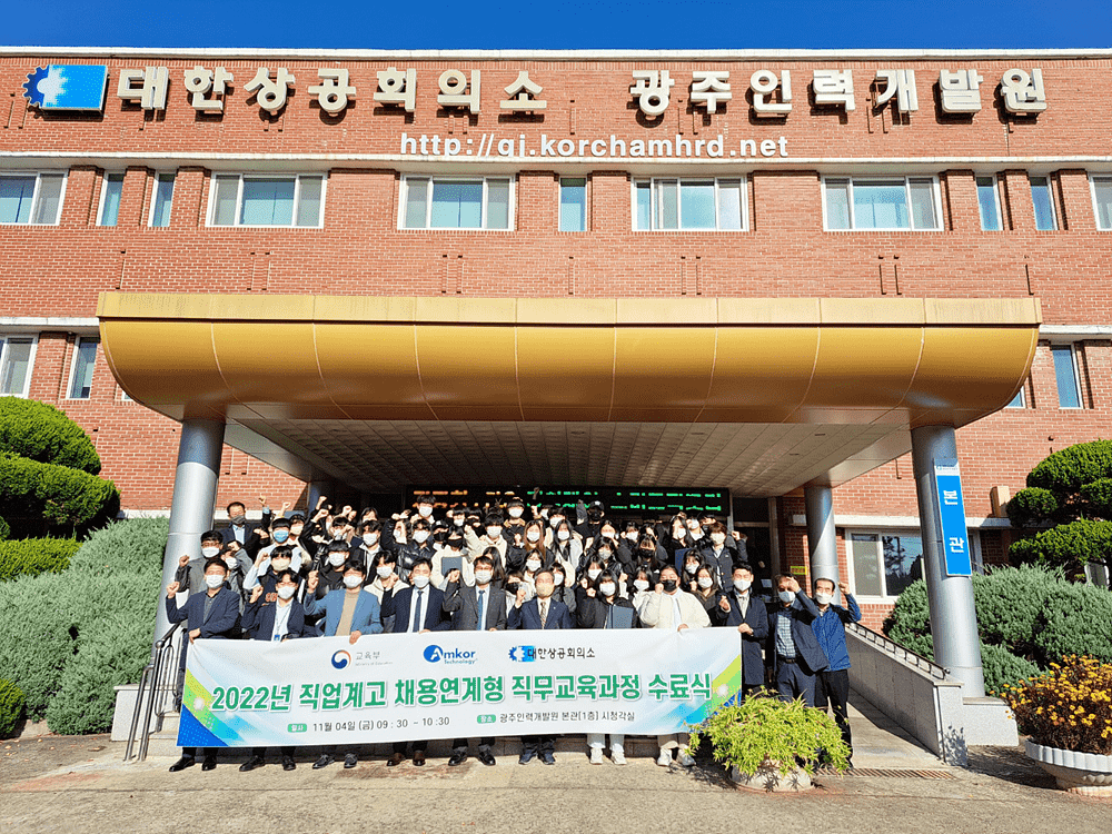 Students outside holding banner at ATK