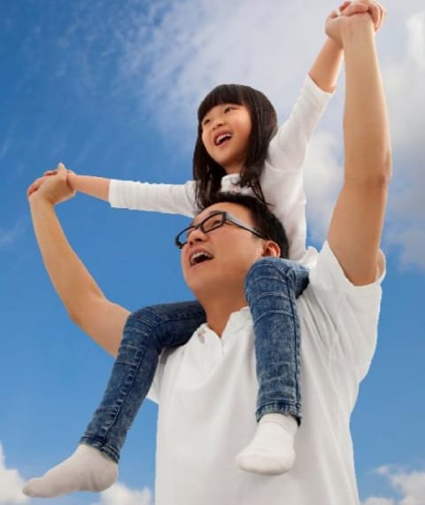 Image shows a father with his daughter on his shoulders laughing