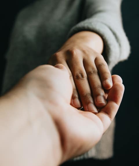 image of two people holding hands tenderly