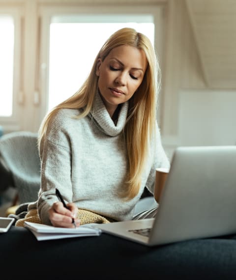 Image shows a blonde girl doing homework